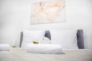 a white bed with two white pillows and a box on it at Ajko Homes - Loft-Apartment mit Parkplatz bei Heidelberg in Dossenheim