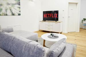 a living room with a couch and a tv at Ajko Homes - Loft-Apartment mit Parkplatz bei Heidelberg in Dossenheim