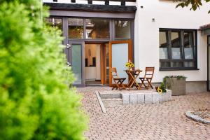 a patio with a table and chairs in front of a house at IDEE living:Loft-Apartment bei Heidelberg in Dossenheim