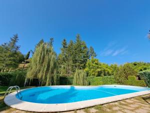 a swimming pool in a garden with a waterfall at B&B Tenuta Campo Magliano in Bigliolo