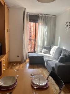 - un salon avec un canapé et une table avec des verres à vin dans l'établissement Samaniego suite, AirPort, ifema turístico, à Madrid