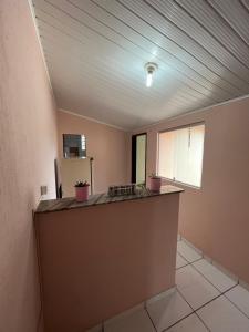 an empty room with a counter and a refrigerator at Kitnet ao lado do centro in Itabira