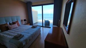 a bedroom with a bed with a view of the ocean at Ocean Breeze Apartment in São Vicente