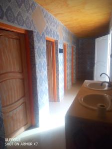 a bathroom with a sink and some doors in a room at L'Oasis in Ksar Ghilane