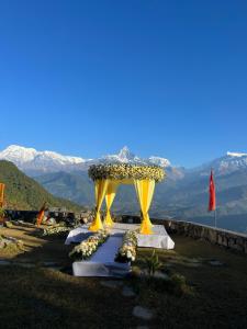 a gazebo on top of a mountain with flowers at Hotel Annapurna View Sarangkot in Pokhara