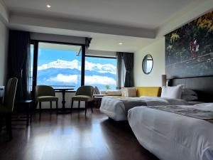 una camera d'albergo con due letti, un tavolo e delle sedie di Hotel Annapurna View Sarangkot a Pokhara Altre 37 foto