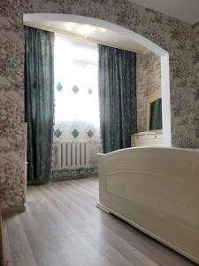 - une chambre avec un lit et une grande fenêtre dans l'établissement Apart 4 Micro District near Orto Say Bazar, à Bishkek
