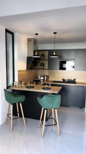 a kitchen with two green chairs and a table at Maison jardin paisible 1 chambre in Mérignac