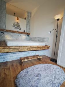 a room with a bed with a bench and a mirror at Panoráma Gold Wellness Apartman in Siófok