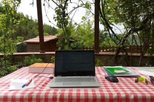 a laptop computer sitting on top of a picnic table at The house in the paradise of Serra. in Chiusi della Verna