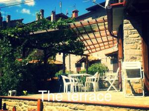 a patio with a table and chairs under a pergola at The house in the paradise of Serra. in Chiusi della Verna
