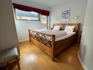 a bedroom with a wooden bed with a window at Åre Travel - Mörviksgården in Åre