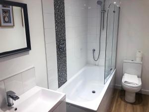 La salle de bains est pourvue d'une douche, d'une baignoire et de toilettes. dans l'établissement Kings Road a new development with unique features, à Newbury