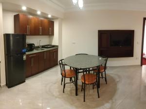 cocina con mesa, sillas y nevera en Monte Cairo Serviced Apartments, en El Cairo