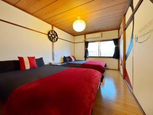 una camera con due letti e una finestra di guesthouse中道 ad Osaka