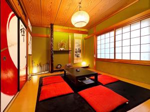 soggiorno con tavolo e tappeti rossi di guesthouse中道 ad Osaka