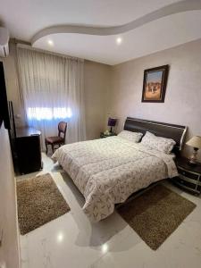 um quarto com uma cama, uma cadeira e uma janela em Stylish Art Deco 2/2 - Best Location in Marrakech! em Marrakech