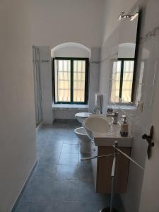 biała łazienka z 2 umywalkami i toaletą w obiekcie Villa Melina lafattoriasecondonoi w mieście Casa Criscione