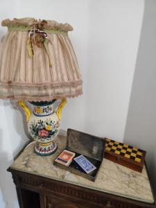Villa Melina lafattoriasecondonoi في Casa Criscione: مصباح فوق طاولة مع مزهرية