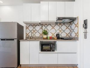 PusokにあるJolenia by J&J Homes At Amani Grand Resort Residences Near Airportの白いキャビネットと電子レンジを備えたキッチン