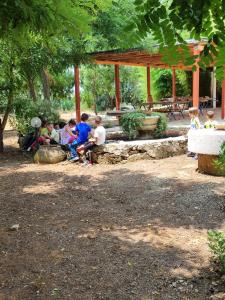 Villa Melina lafattoriasecondonoi في Casa Criscione: مجموعة من الأطفال يجلسون على المقاعد في الحديقة