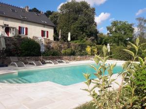 a swimming pool in front of a house at Le Cerisier in Saint-Symphorien-de-Marmagne