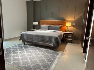 a bedroom with a large bed and a rug at One Constitution Avenue by Goldfinch, Luxury apartments near Diplomatic Enclave and Serena in Islamabad
