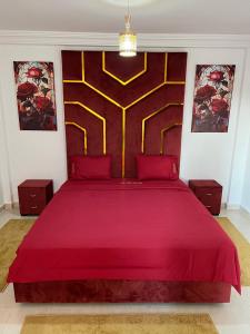 Schlafzimmer mit einem roten Bett mit einem großen Kopfteil in der Unterkunft Flowers home in Oujda