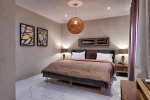 um quarto com uma cama e uma luz pendente em 10 bedroom Luxurious Villa em East Legon