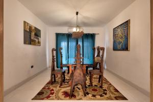un comedor con mesa y sillas sobre una alfombra en 10 bedroom Luxurious Villa, en East Legon