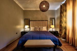 - une chambre avec un lit bleu et deux lampes dans l'établissement 10 bedroom Luxurious Villa, à East Legon