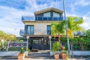 una casa con una valla y palmeras delante de ella en Casa Bohème, en Santa Susanna