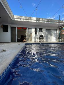 una piscina con acqua blu di fronte a un edificio di Casa Encanto Luz del Mar, Con Piscina Privada a Herradura