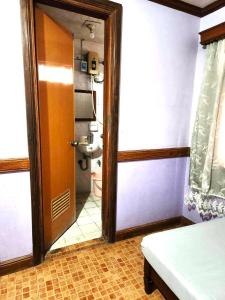 Habitación con baño con puerta y aseo. en Family Room in Bato, Camarines Sur 