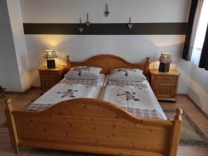 a bedroom with a wooden bed and two night stands at Gästehaus Vorderwahllehen in Schönau am Königssee