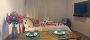 サンタ・テレサにあるVillaggio di Itália Chalésのベッド1台、テーブル(2皿付)が備わる客室です。
