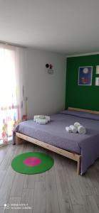 1 dormitorio con 1 cama grande y pared verde en La casita, en Civitavecchia