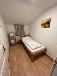 um pequeno quarto com uma cama num quarto em Apartman Vanja em Pozega