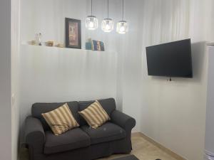 a living room with a couch and a flat screen tv at Apartamento La Mamola in La Mamola