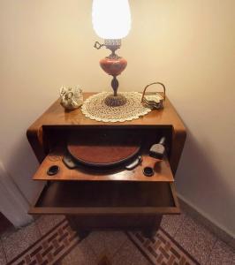 une table avec une lampe au-dessus dans l'établissement Zeta's vintage garden house, à Sparte