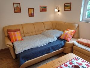 ein Sofa mit Kissen darauf im Zimmer in der Unterkunft Ferienhaus am Wald in Sangerhausen