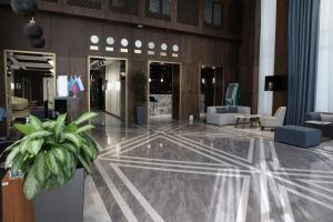 een lobby met een potplant in een gebouw bij Green Park Hotel in Tasjkent