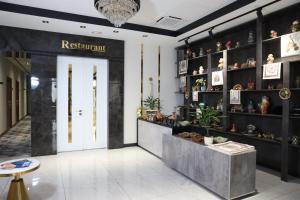 een lobby van een winkel met een deur en planken met planten bij Green Park Hotel in Tasjkent