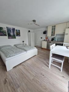 ein Schlafzimmer mit einem Bett und einem Tisch sowie eine Küche in der Unterkunft Waldbergperle Ernsbach in Forchtenberg