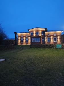 una casa con luces en la parte delantera de la noche en Dorfblick vom Muckesberg en Lübeck