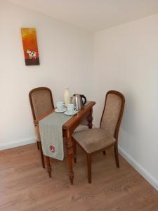 stół z 2 krzesłami i zestaw do parzenia herbaty. w obiekcie Dorfblick vom Muckesberg w Lubece