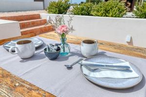 een houten tafel met borden en keukengerei erop bij Quinta do Ourives in Carvoeiro