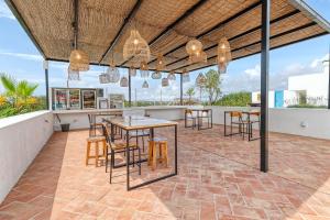 un patio al aire libre con mesas, sillas y lámparas de araña en Quinta do Ourives en Carvoeiro