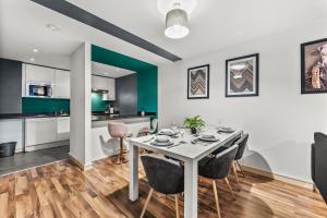 cocina y comedor con mesa y sillas en Spacious Central Manchester Apartment - Sleeps 8, en Mánchester
