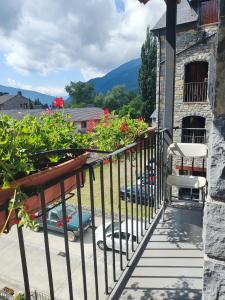 a balcony with plants and a chair on a building at Apart. Casa Juaneta Pirineo-Ordesa in Broto